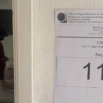 Placa de seção eleitoral com o número 112 na porta de uma escola