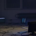 Sala escura com monitores e cabos de equipamento