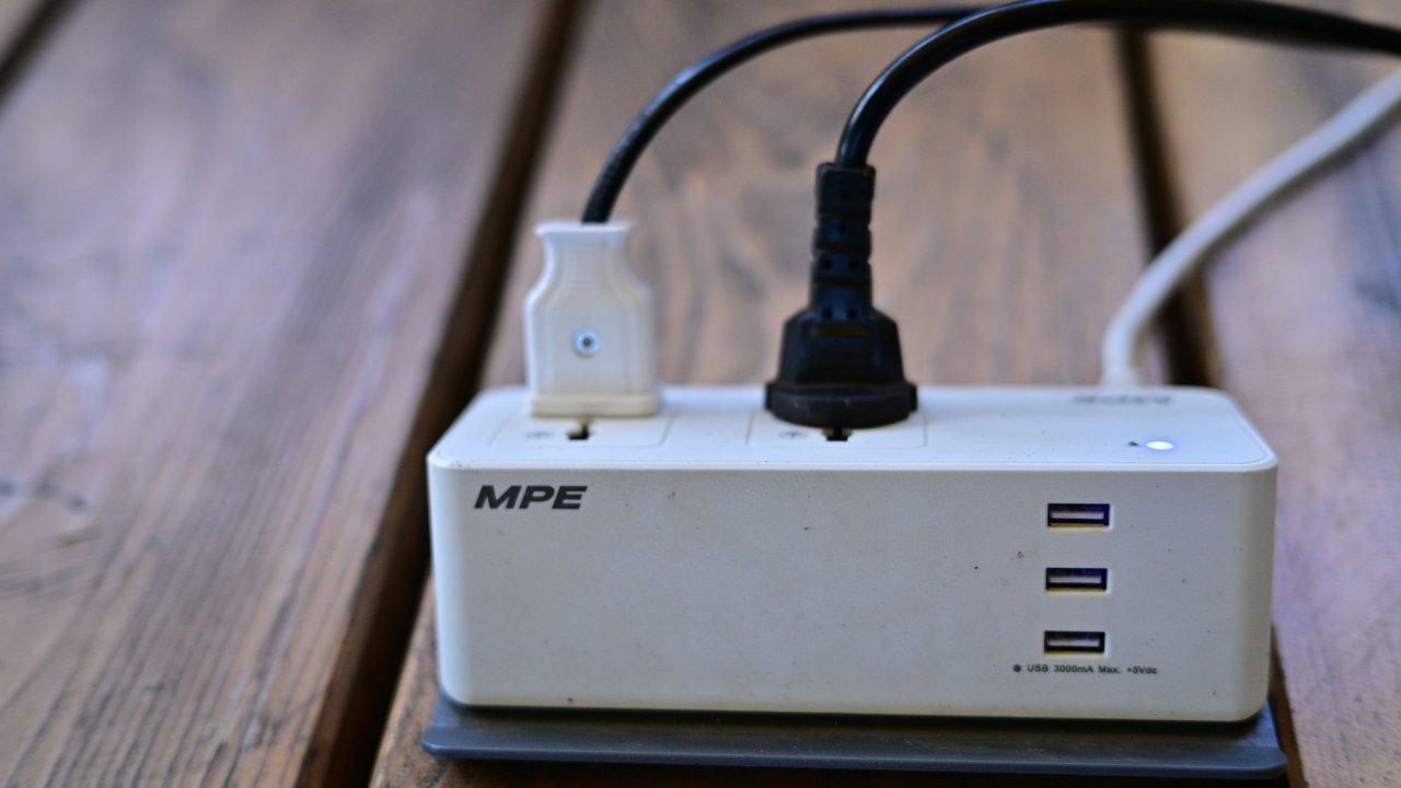 Filtro de linha com tomadas e portas USB sobre mesa de madeira