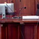 Púlpito de madeira com microfones e monitor num auditório