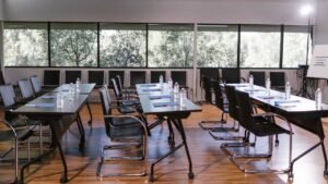Sala de reuniões vazia com mesas longas e cadeiras