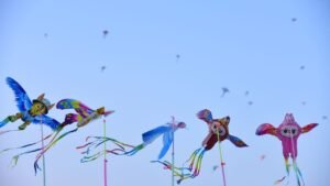 Pipas coloridas em formato de pássaros voando no céu azul