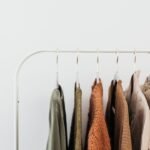 Arara branca com peças de roupa em tons neutros, num fundo claro