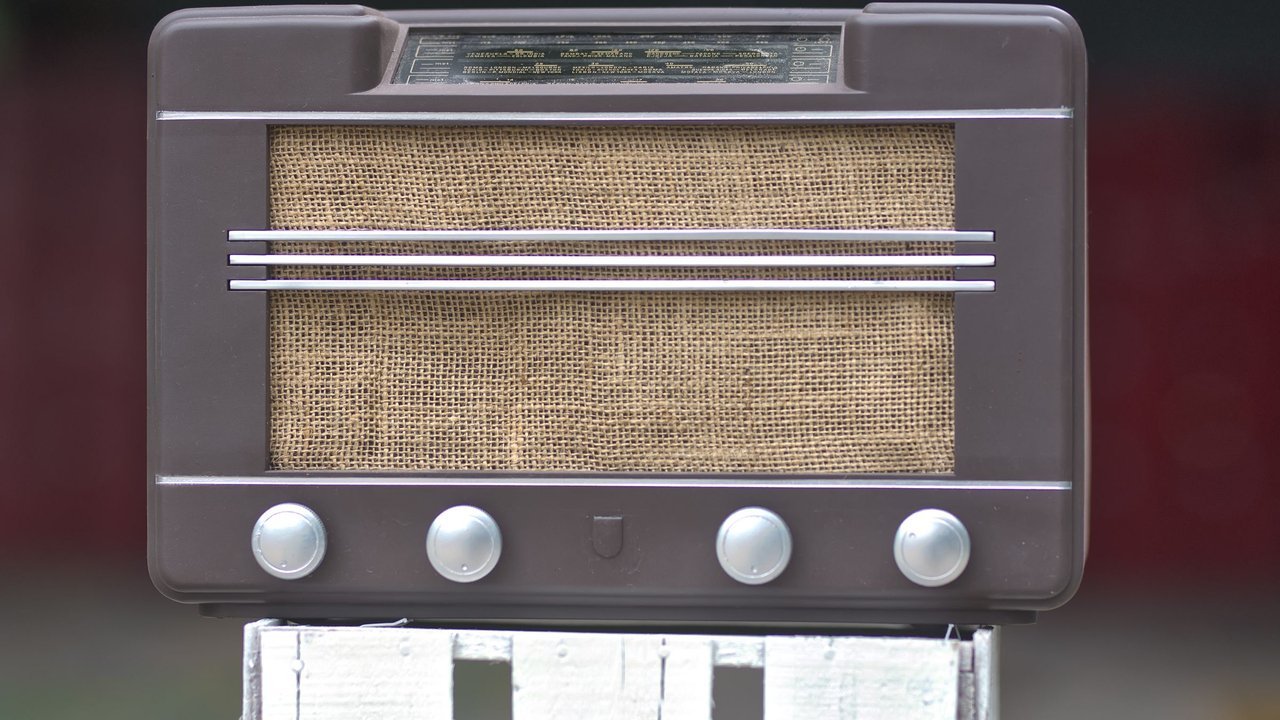 Rádio antigo de madeira com tela de tecido na frente