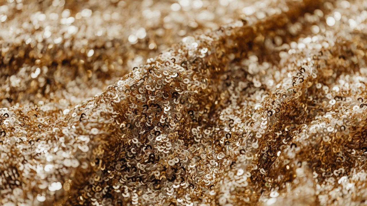 Close de glitter dourado, textura brilhante de festa