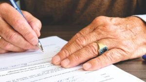Mãos assinando um documento com caneta