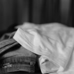 Calça jeans e camiseta branca dobradas, em preto e branco