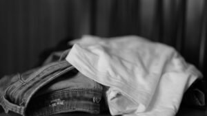 Calça jeans e camiseta branca dobradas, em preto e branco