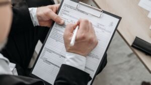 Mãos preenchendo um formulário numa prancheta