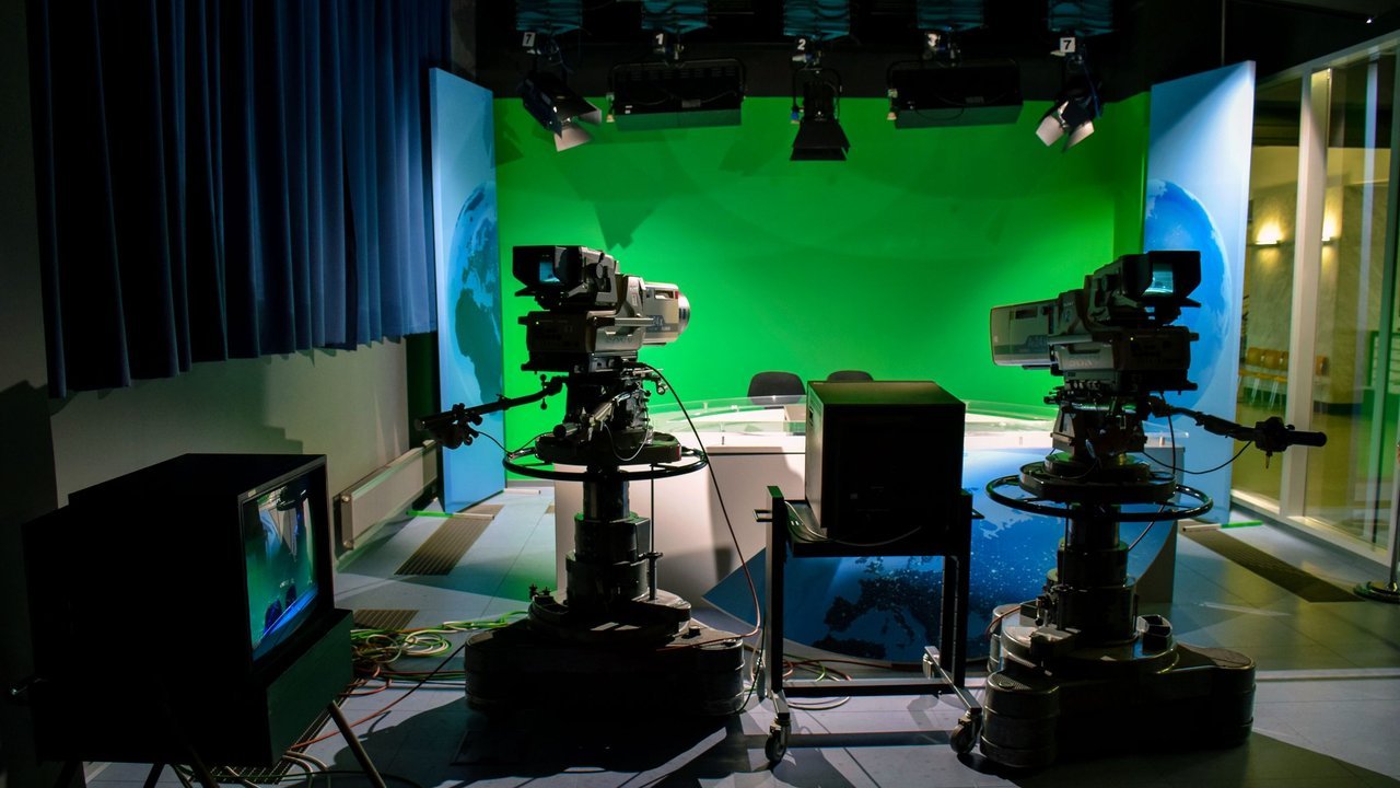 Estúdio de TV com câmeras profissionais e fundo verde
