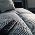 Controle remoto sobre o assento de um sofá cinza
