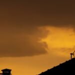 Silhueta de telhado com antena parabólica ao pôr do sol