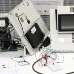 Urna eletrônica aberta com placas e cabos expostos durante teste técnico