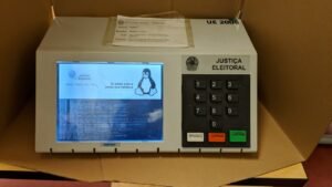 Urna eletrônica da Justiça Eleitoral apoiada sobre uma mesa