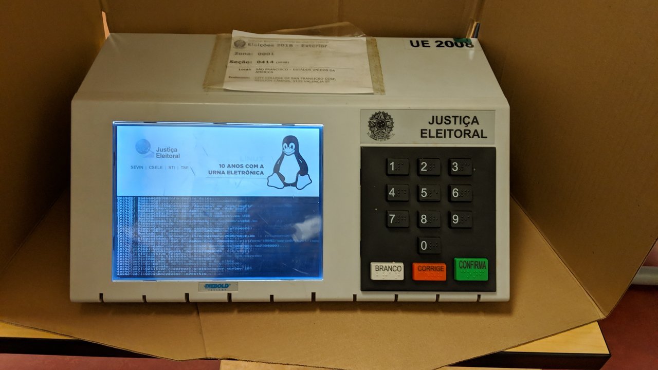 Urna eletrônica da Justiça Eleitoral apoiada sobre uma mesa